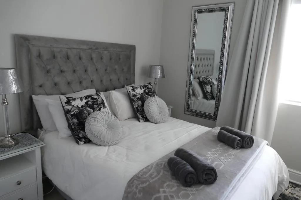 Elegantly styled bedroom with upholstered headboard and fresh white linens