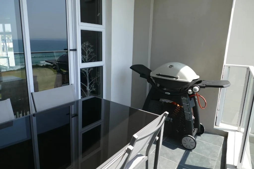 Outdoor patio with gas braai grill and ocean view beyond
