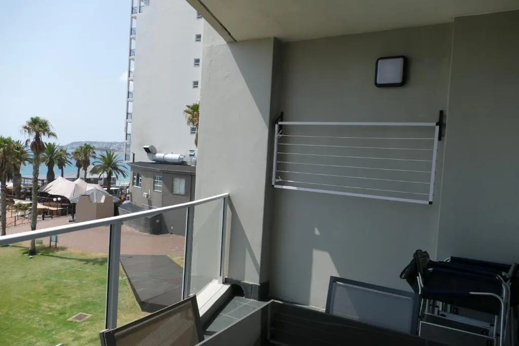 Balcony with metal railing overlooking coastal town and ocean view