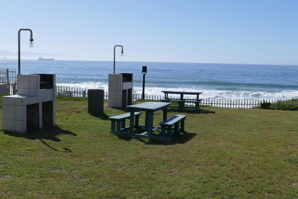 Beachfront picnic area with tables, shower facilities, ocean view