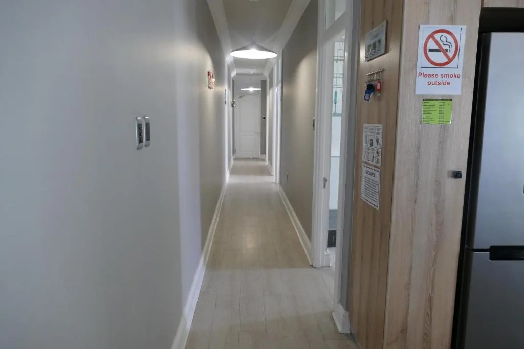 Clean modern hallway with white walls and light flooring leading to rooms