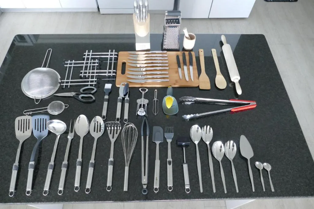 Organized kitchen utensils and cutlery display on dark countertop