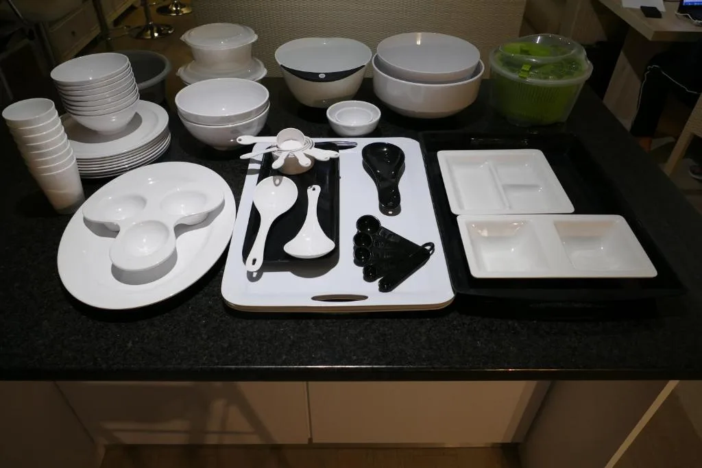 Kitchen counter display of dinnerware, serving dishes, and utensils collection
