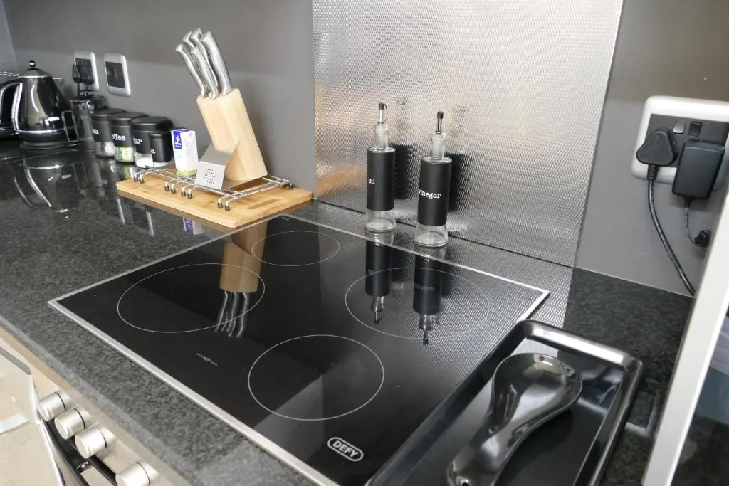 Modern kitchen with induction cooktop, knife block, and granite countertops