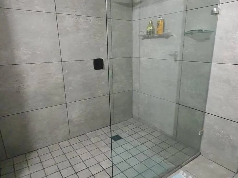 Modern walk-in shower with glass enclosure and tile flooring