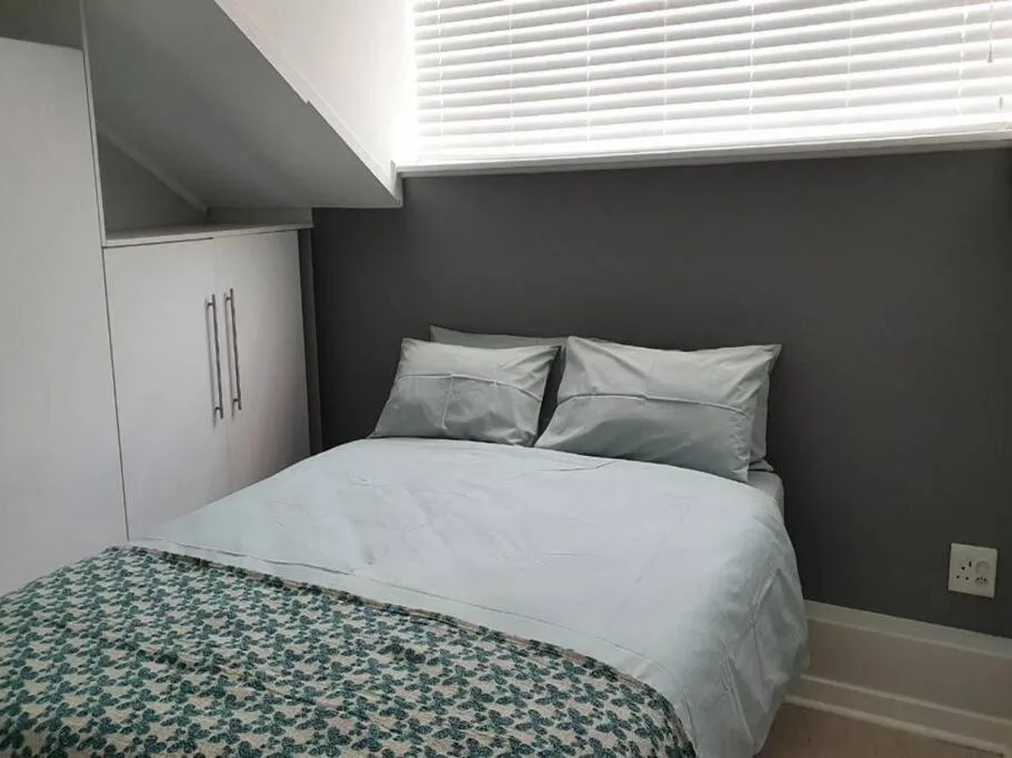 Modern bedroom with queen bed, gray accent wall, and built-in wardrobe