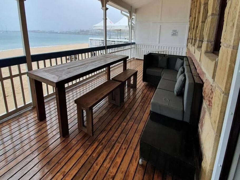 Beachfront deck with dining table, seating, and ocean view