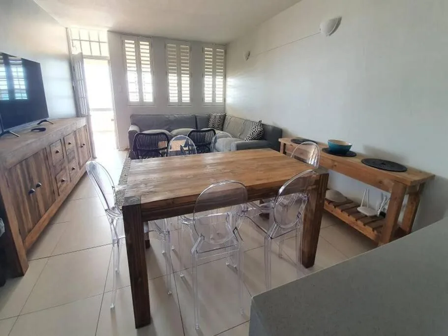 Open-plan dining area with wooden table and modern transparent chairs