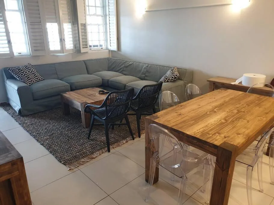 Open-plan living area with gray sectional sofa and wooden dining table