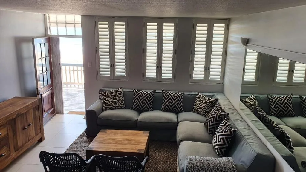 Modern lounge with sectional sofa, geometric pillows, and deck access