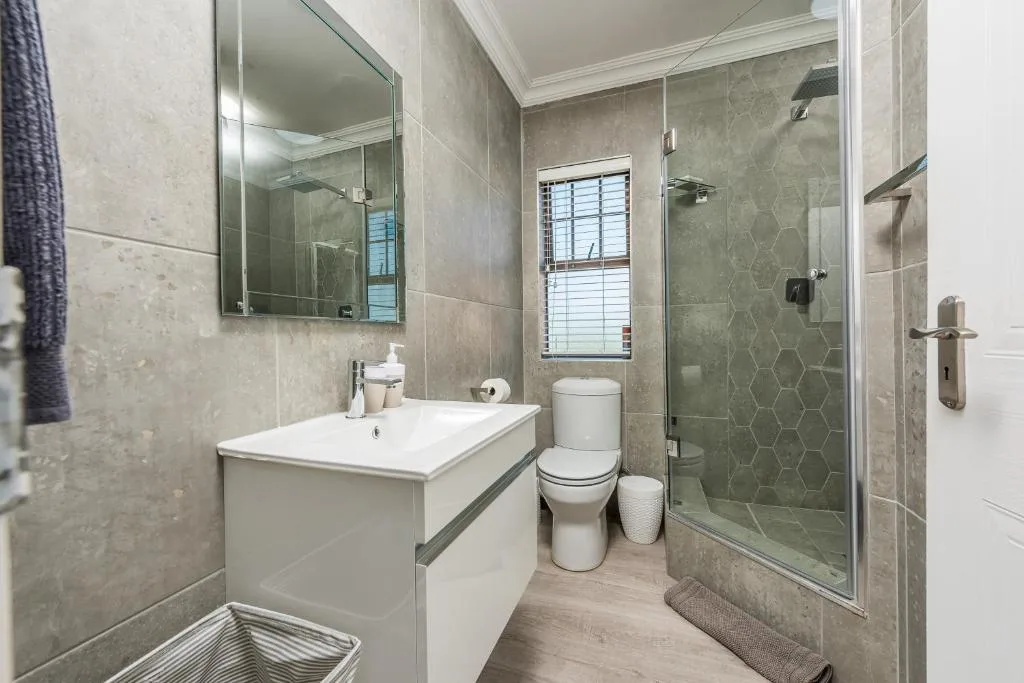 Modern bathroom with vanity, toilet, and walk-in shower enclosure