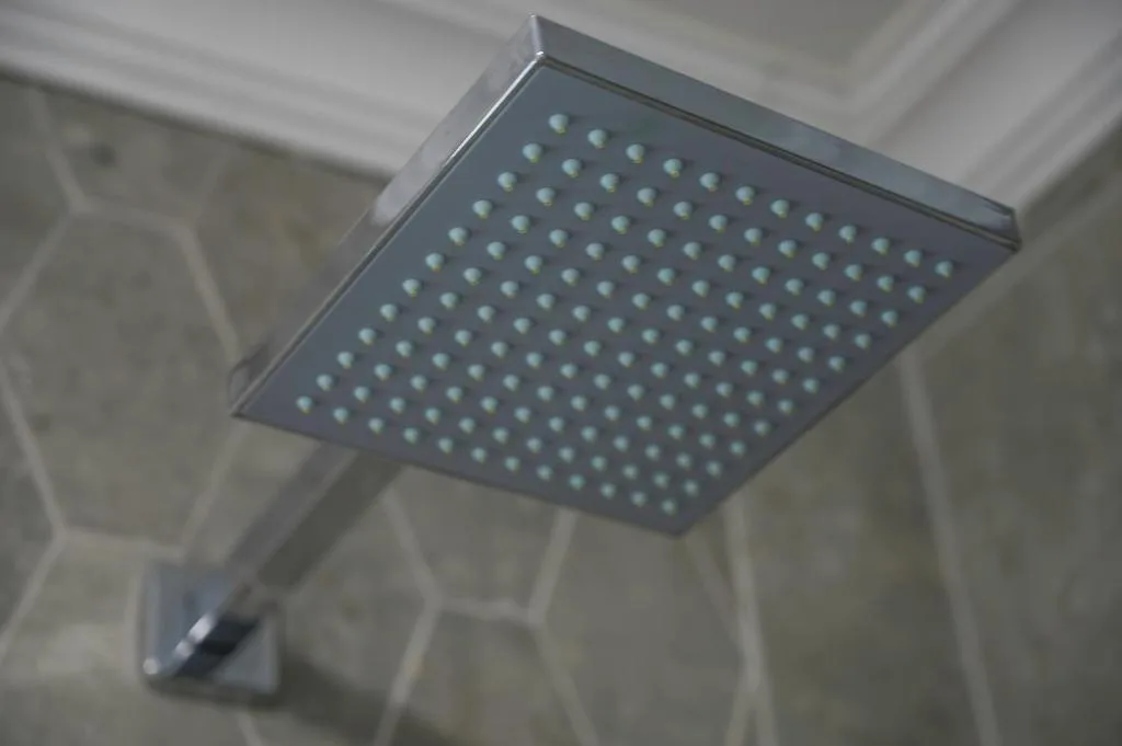 Modern square rainfall showerhead mounted on bathroom ceiling