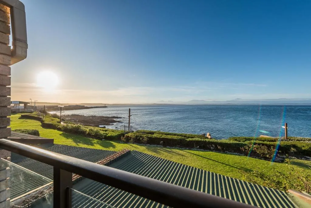 Panoramic ocean view from property balcony with mountains in distance