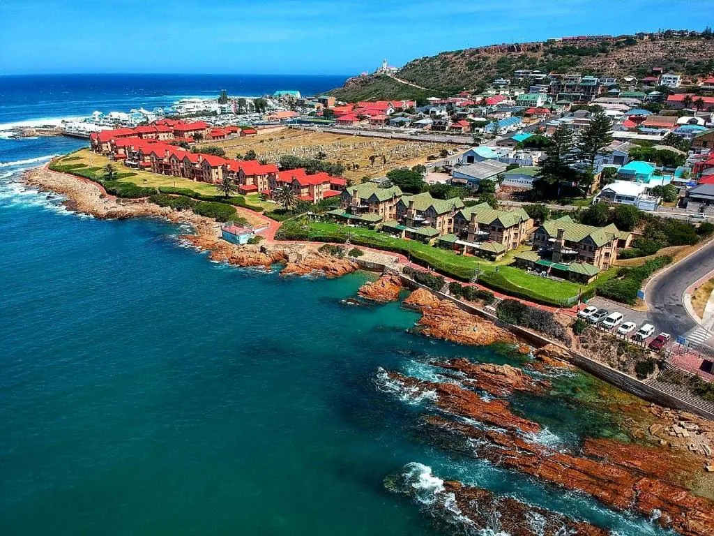 Aerial coastal view of Mossel Bay with turquoise ocean and red-roofed buildings