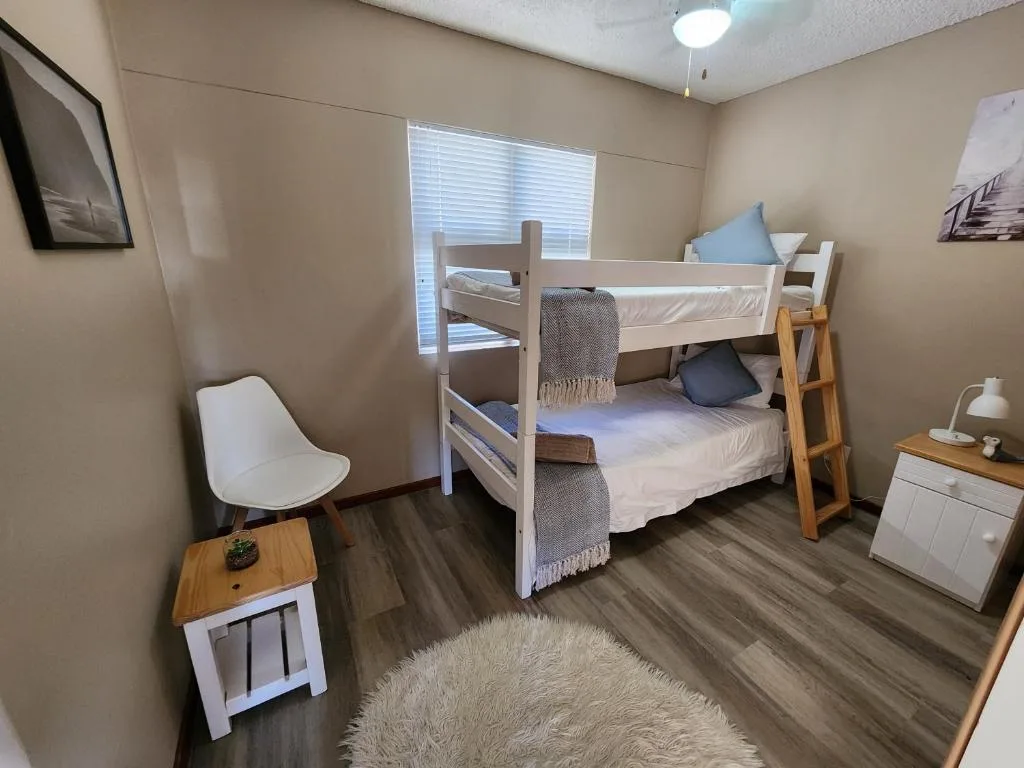 Bright bedroom with white wooden bunk beds and modern furnishings