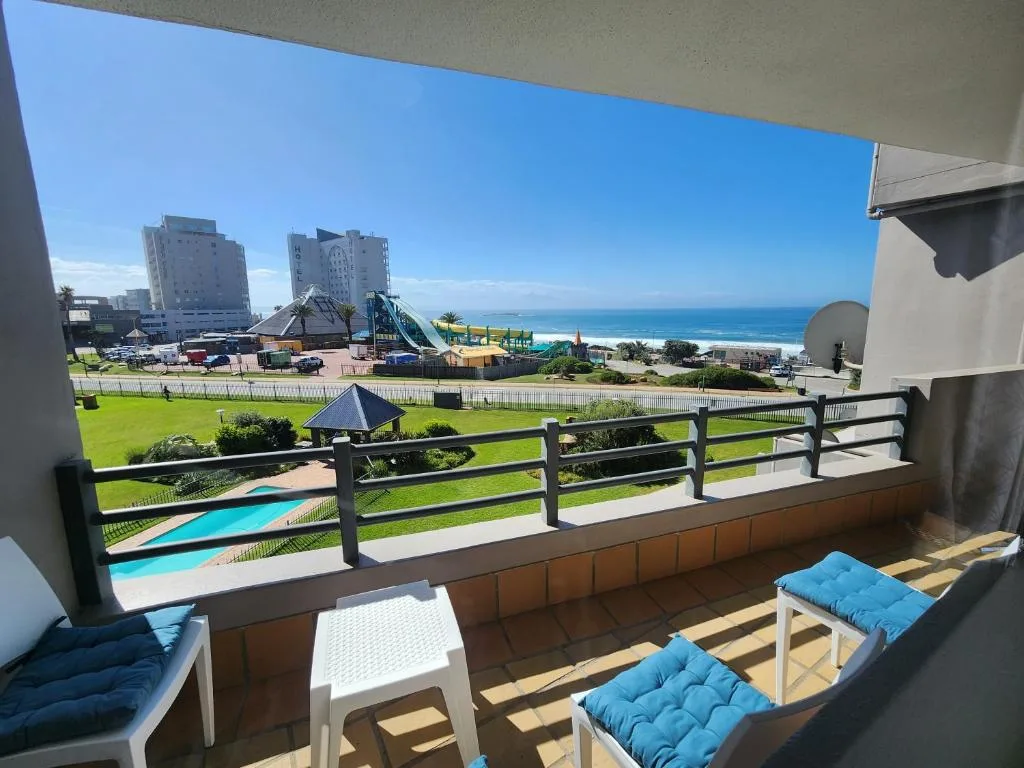 Spacious balcony with ocean view, lounge chairs, and coastal landscape