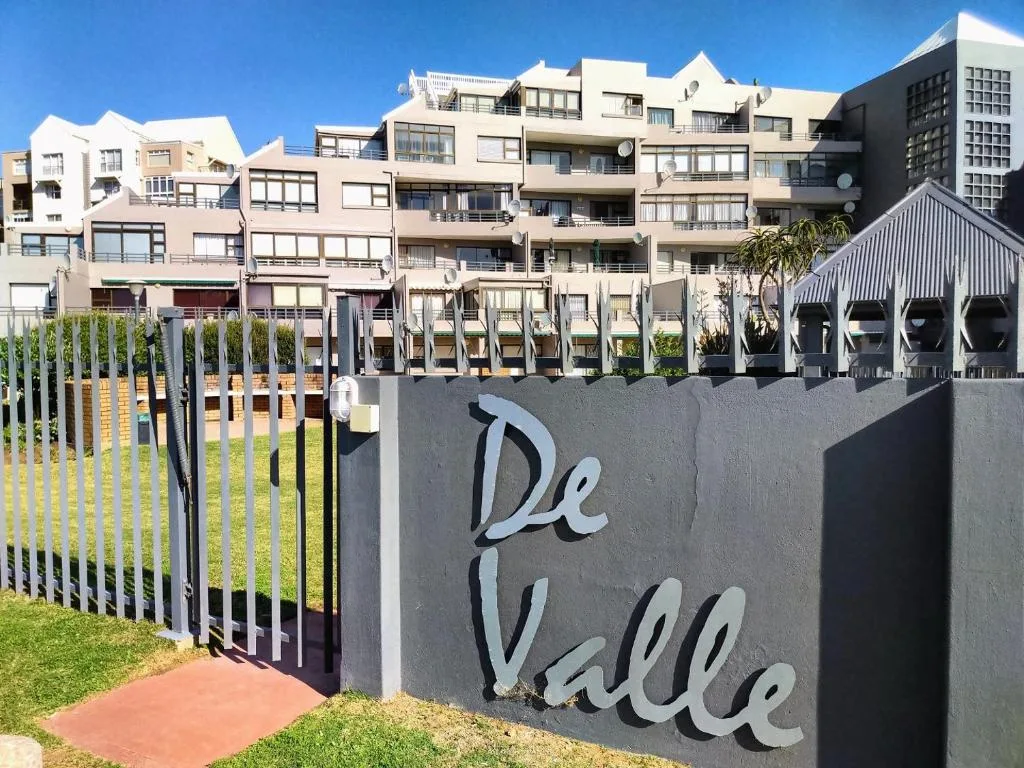 Modern apartment building facade with gated entrance and signage
