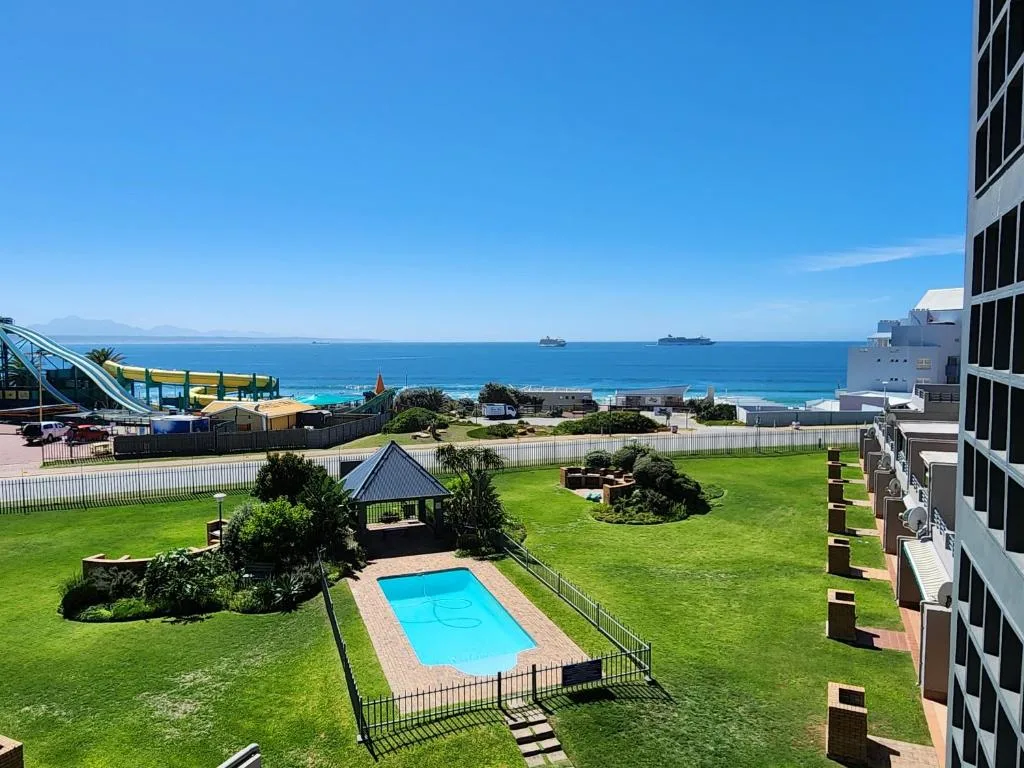 Scenic ocean view with swimming pool and manicured gardens below
