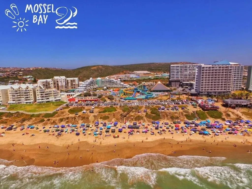 Scenic aerial view of Mossel Bay beach with golden sand and colorful umbrellas