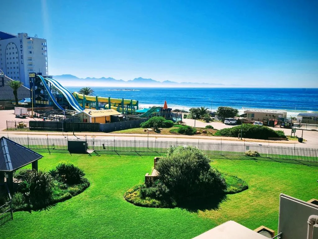Ocean and mountain vista from manicured garden with beach access below