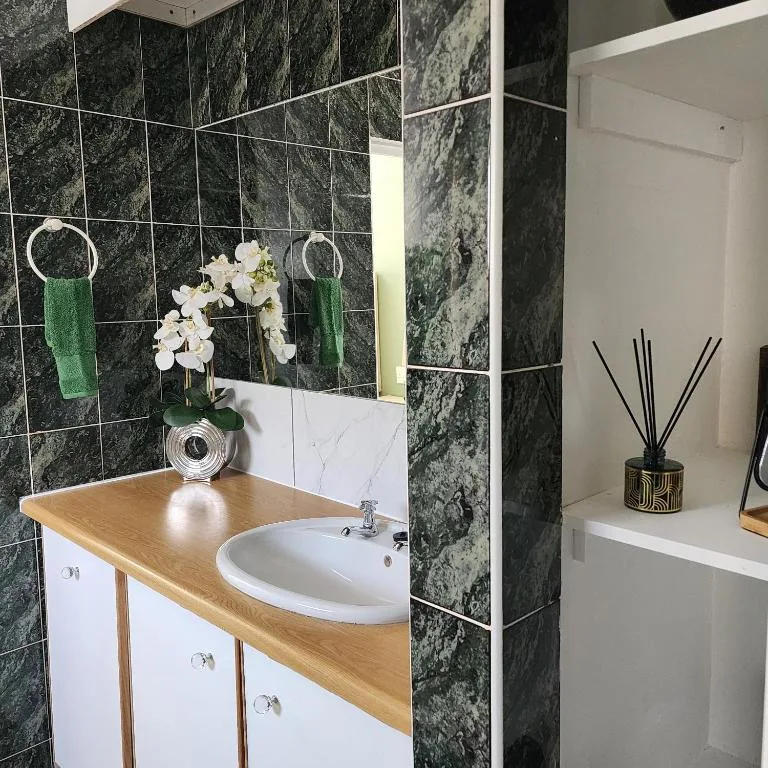 Modern bathroom vanity with marble tiles, white orchids, and decorative accessories