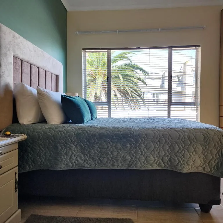 Bedroom with queen bed, teal accent wall, and sliding glass doors to deck
