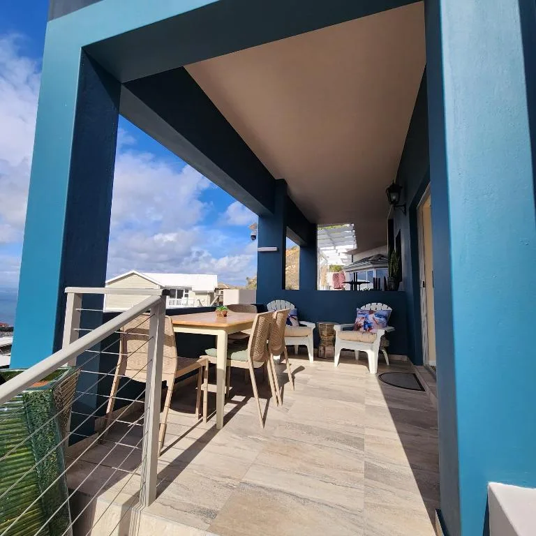 Modern covered patio with dining table overlooking coastal landscape