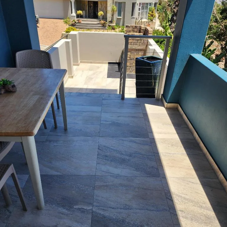 Spacious outdoor patio with dining table and ocean views