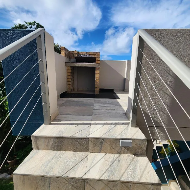 Modern entrance with concrete steps and metal railings leading to property
