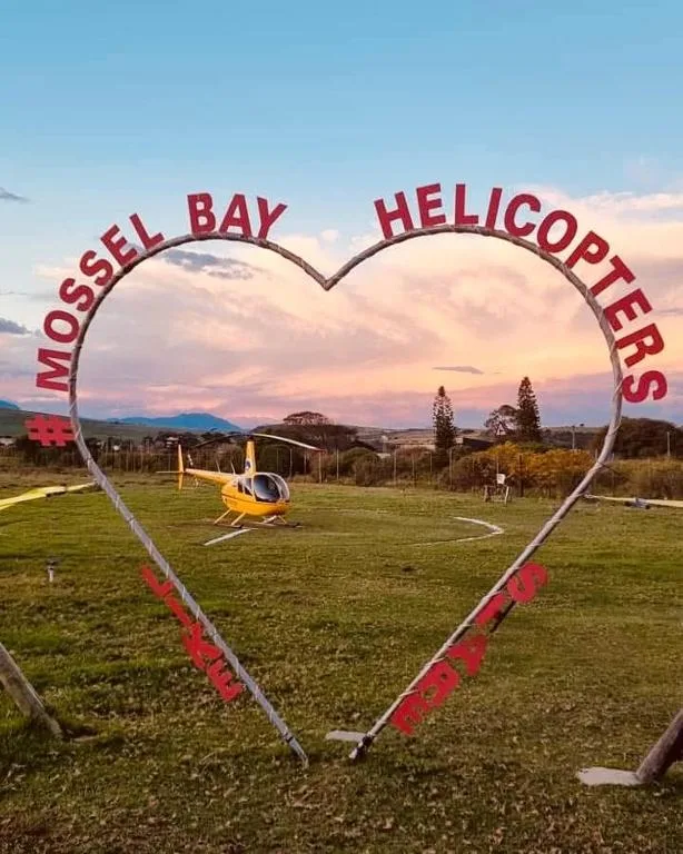 Mossel Bay Helicopters heart-shaped sign with helicopter and mountains