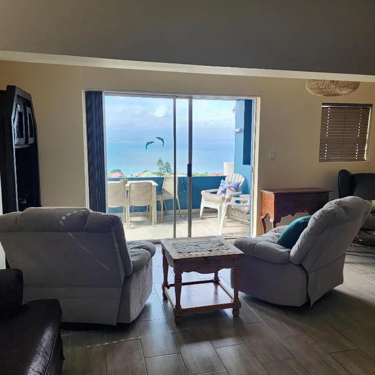 Spacious lounge with comfortable seating and ocean view through glass doors