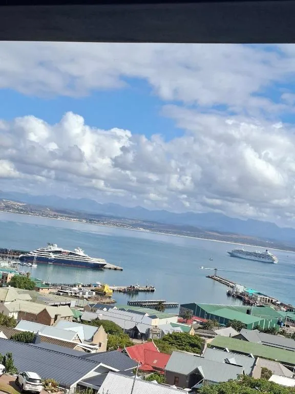 Scenic coastal view of Mossel Bay harbor with cruise ships and mountains