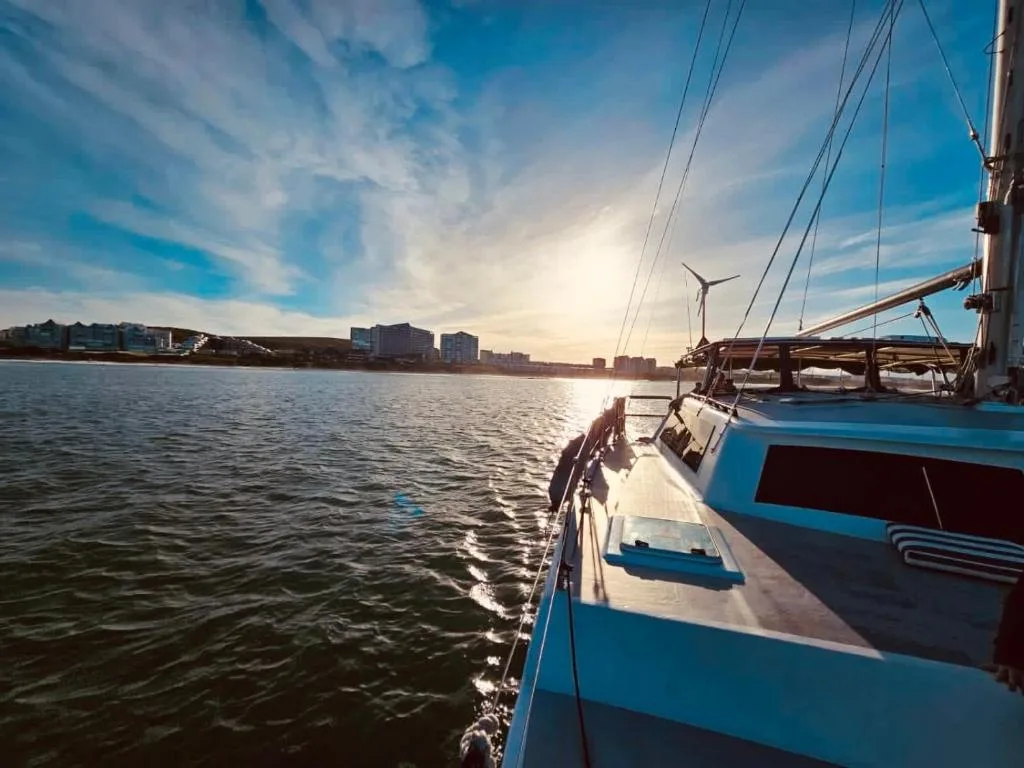 Scenic waterfront view from boat with coastal buildings and sunset
