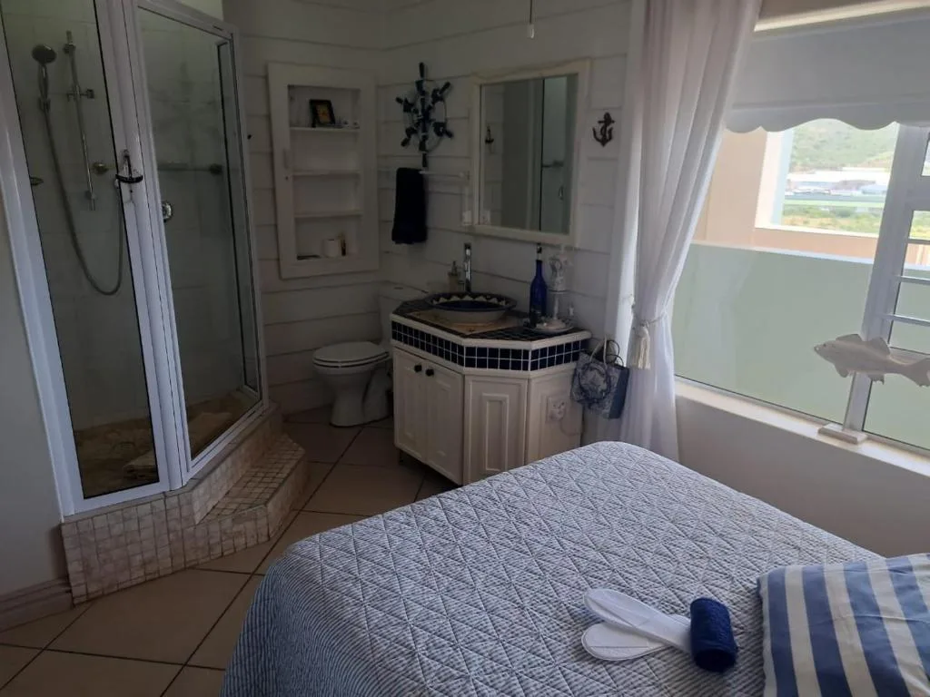 Bedroom with en-suite bathroom, nautical decor, and lagoon views