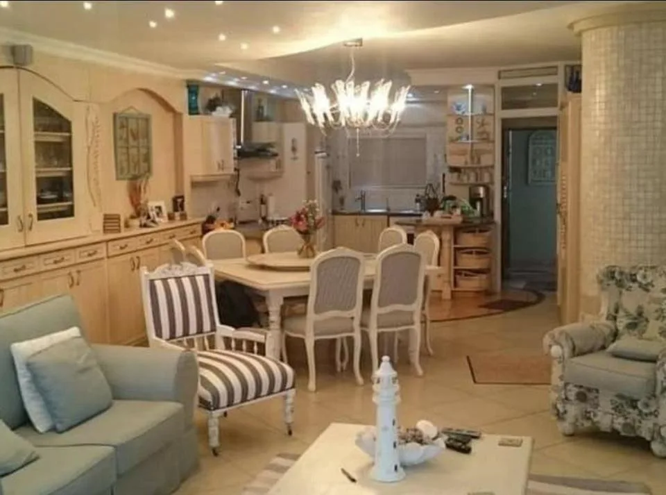 Open-plan lounge and dining area with elegant furniture and chandelier