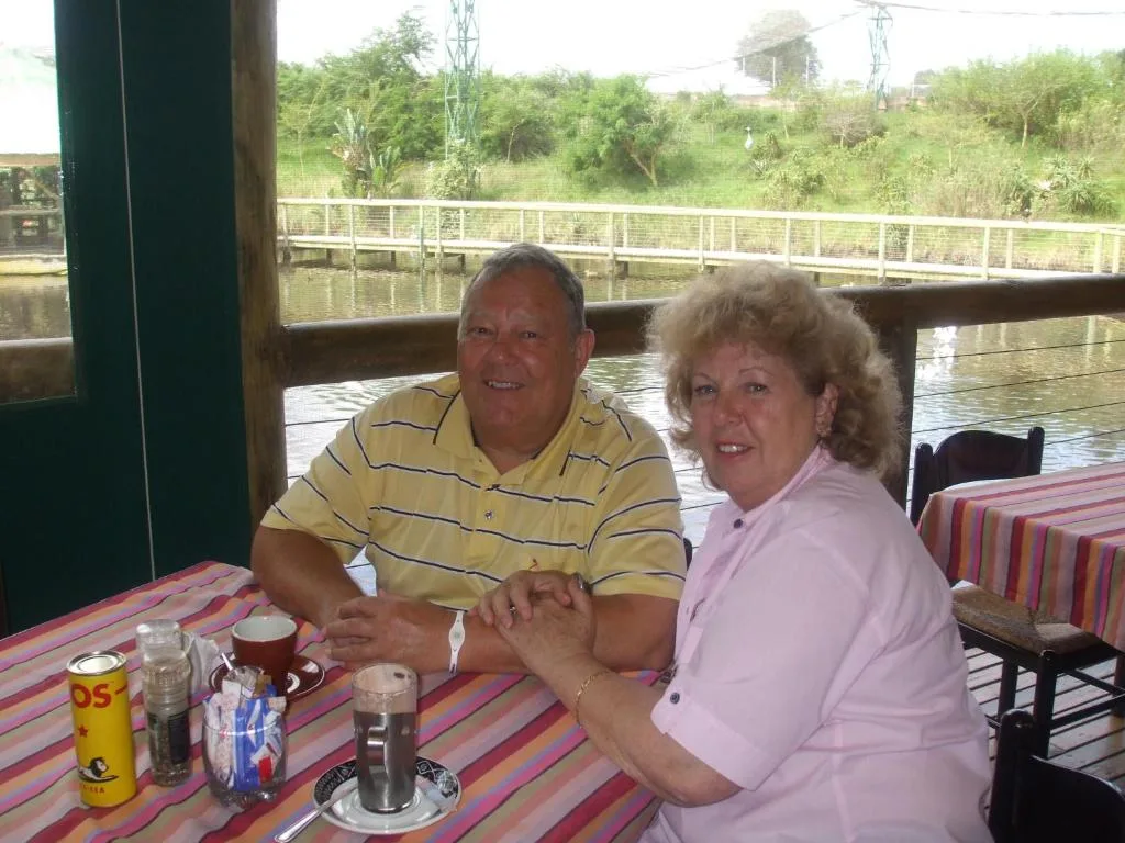 Waterfront deck with striped tablecloth overlooking lagoon and lush vegetation