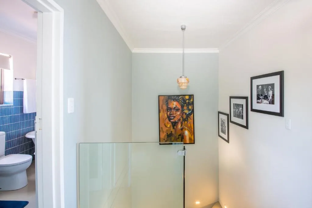 Modern bathroom with glass shower enclosure and framed artwork on walls