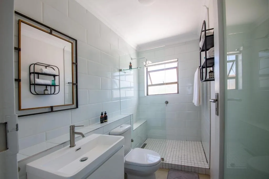 Bright modern bathroom with vanity, toilet, and walk-in shower enclosure