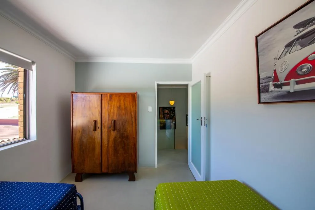 Bright bedroom with twin beds and wooden wardrobe storage