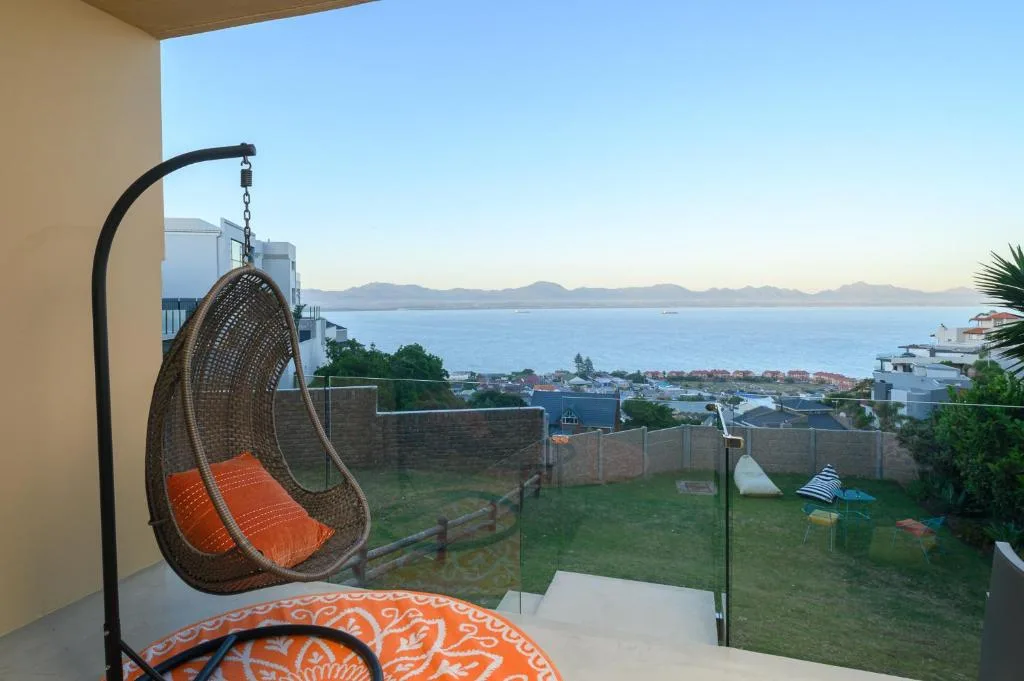 Hanging egg chair on deck overlooking coastal town and ocean