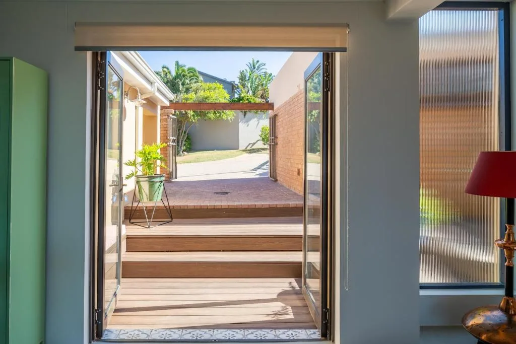 Wooden deck with steps leading to courtyard garden and brick walls