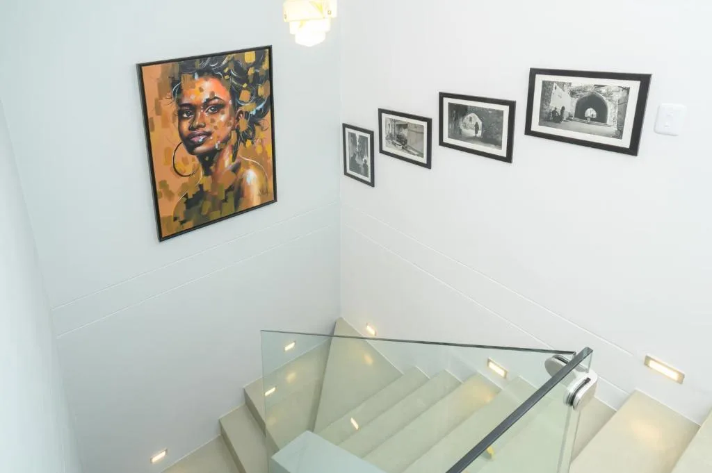 Modern stairwell with contemporary art gallery wall featuring framed portraits