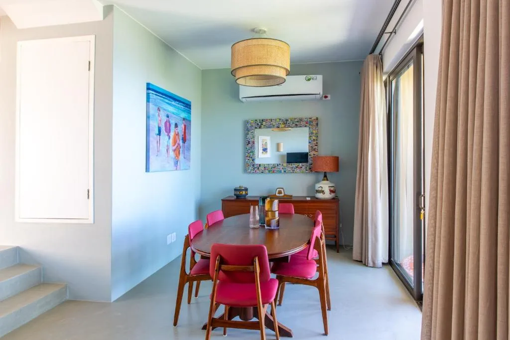 Modern dining area with round table and vibrant pink chairs, contemporary decor