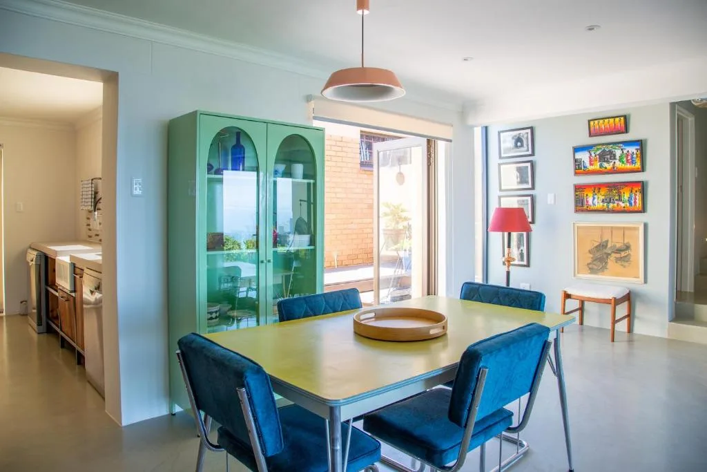 Modern dining table with blue chairs and pendant lighting