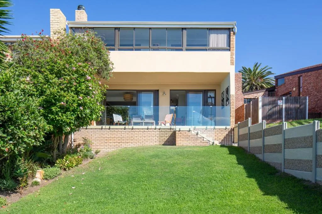 Modern two-story brick home with manicured lawn and garden landscaping
