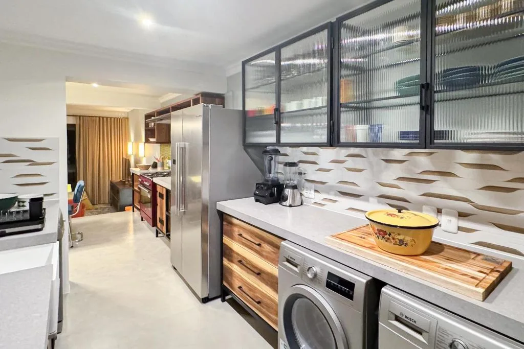 Modern kitchen with stainless steel appliances and geometric backsplash tile