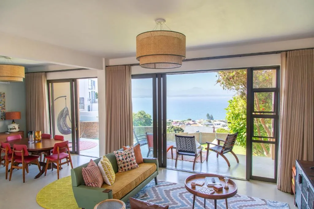 Modern lounge with coastal views, colorful seating, and ocean-facing glass doors