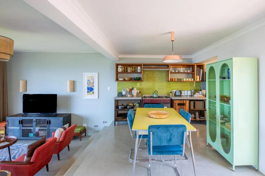 Open-plan living area with dining table, kitchen, and entertainment seating