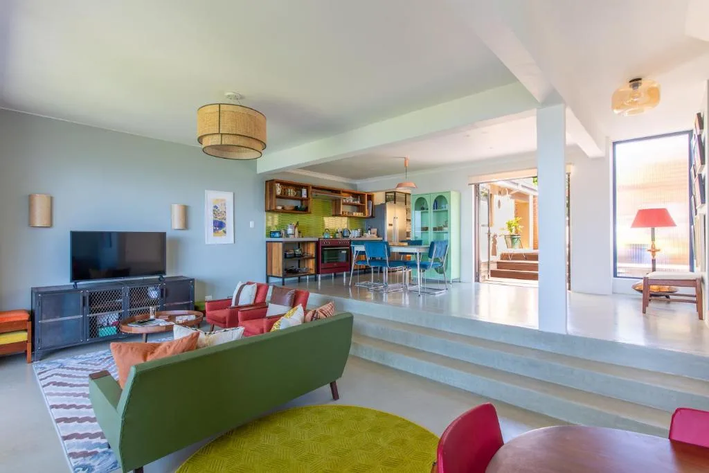 Modern lounge with green sofa, TV, and open-plan kitchen connection