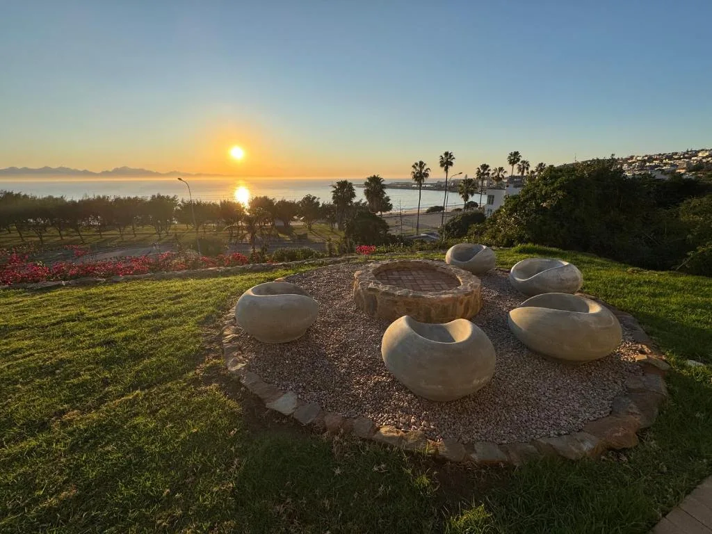 Sunrise over lagoon with palm trees and coastal mountains in distance
